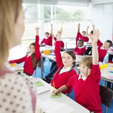 dzieci podnoszą ręce w klasie